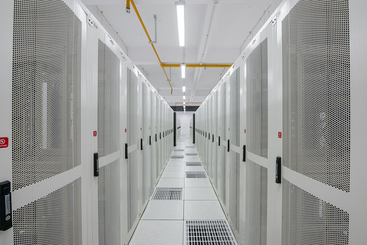 A corridor between two rows of closed server racks in a data centre