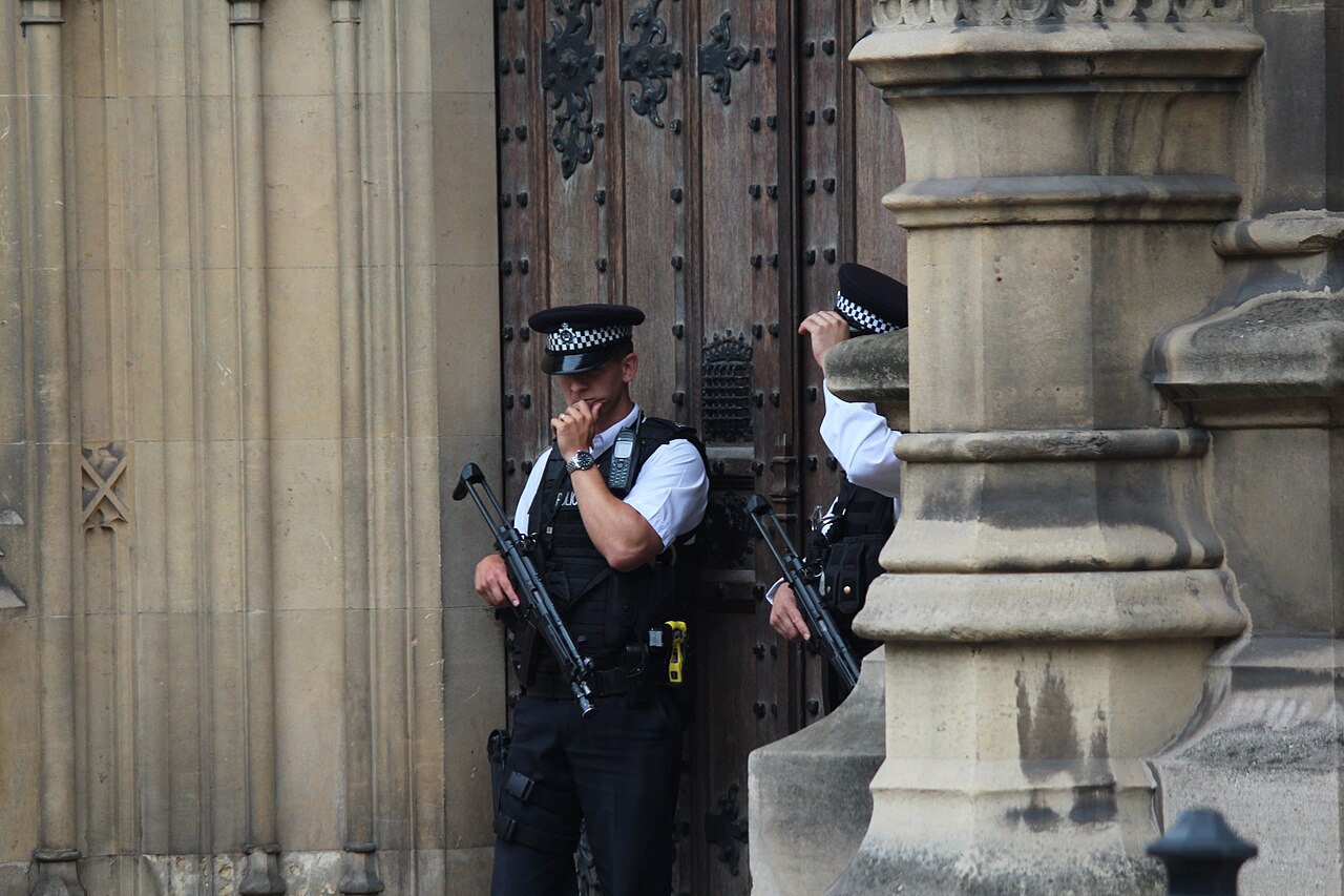 Two armed police officers standing guard at a doorway of the Palace of Westminster