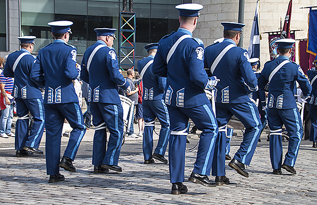 Orange Order marching band members in uniform parading through a town centre