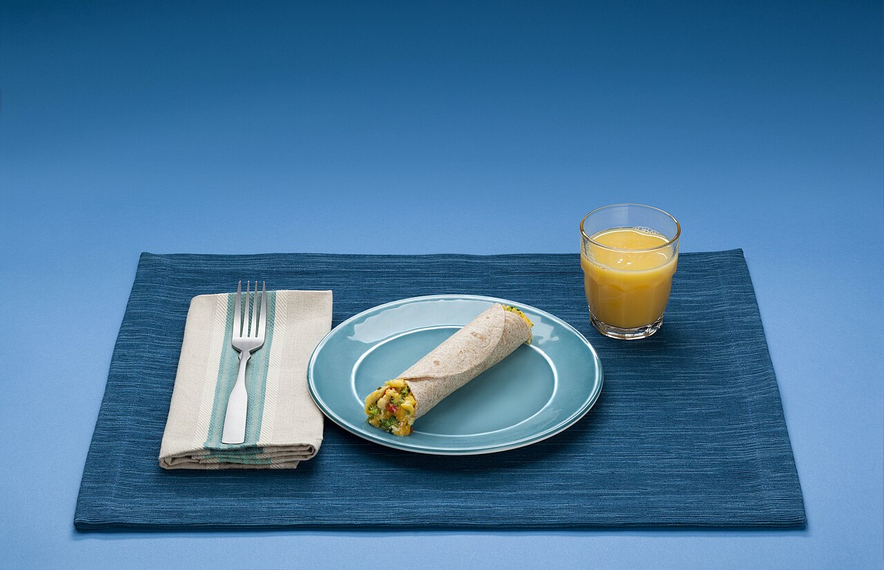 A breakfast plate showing grains, protein foods, dairy, vegetables and fruit