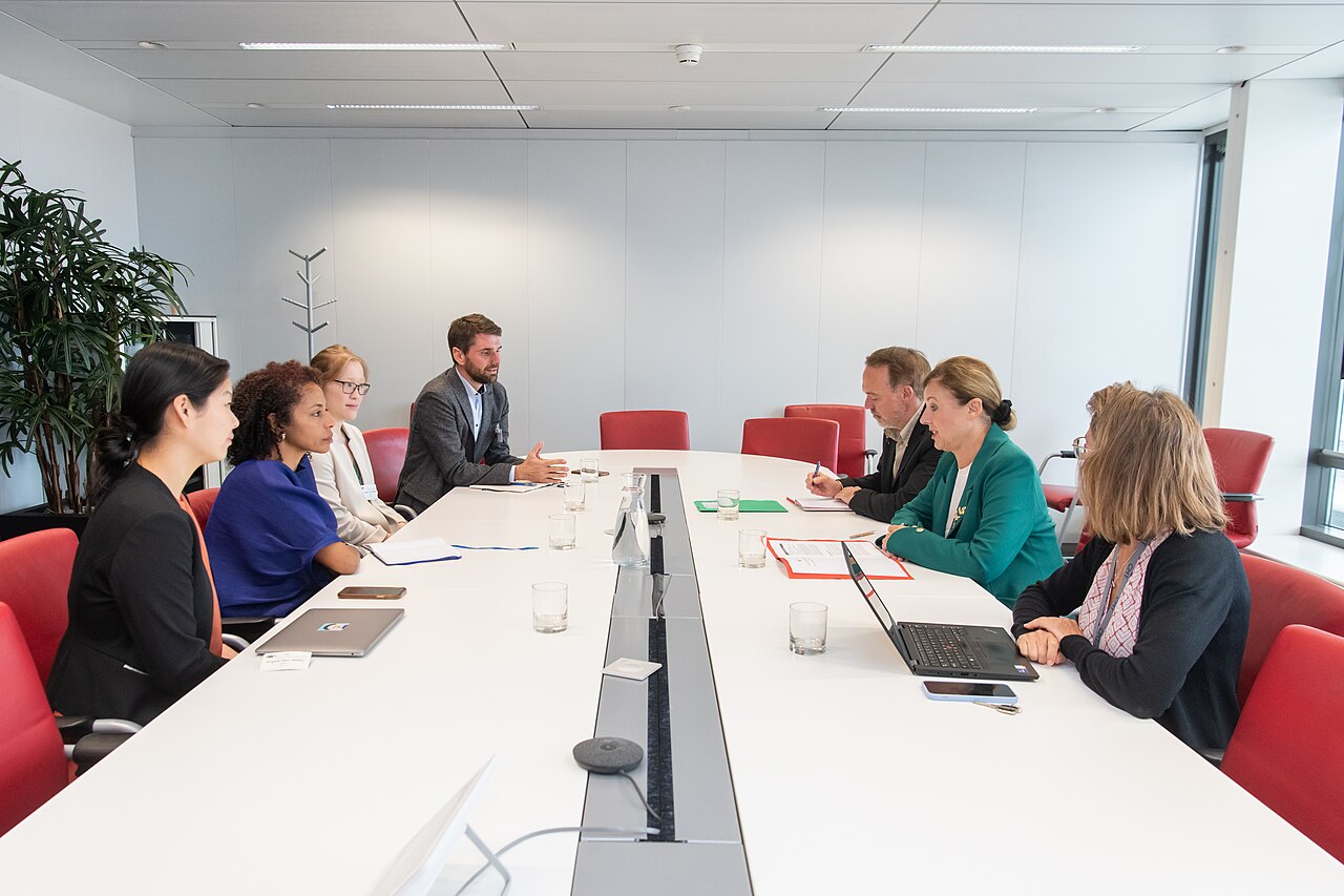 OpenAI representatives sitting at a conference table talking with European Commission officials in a meeting room