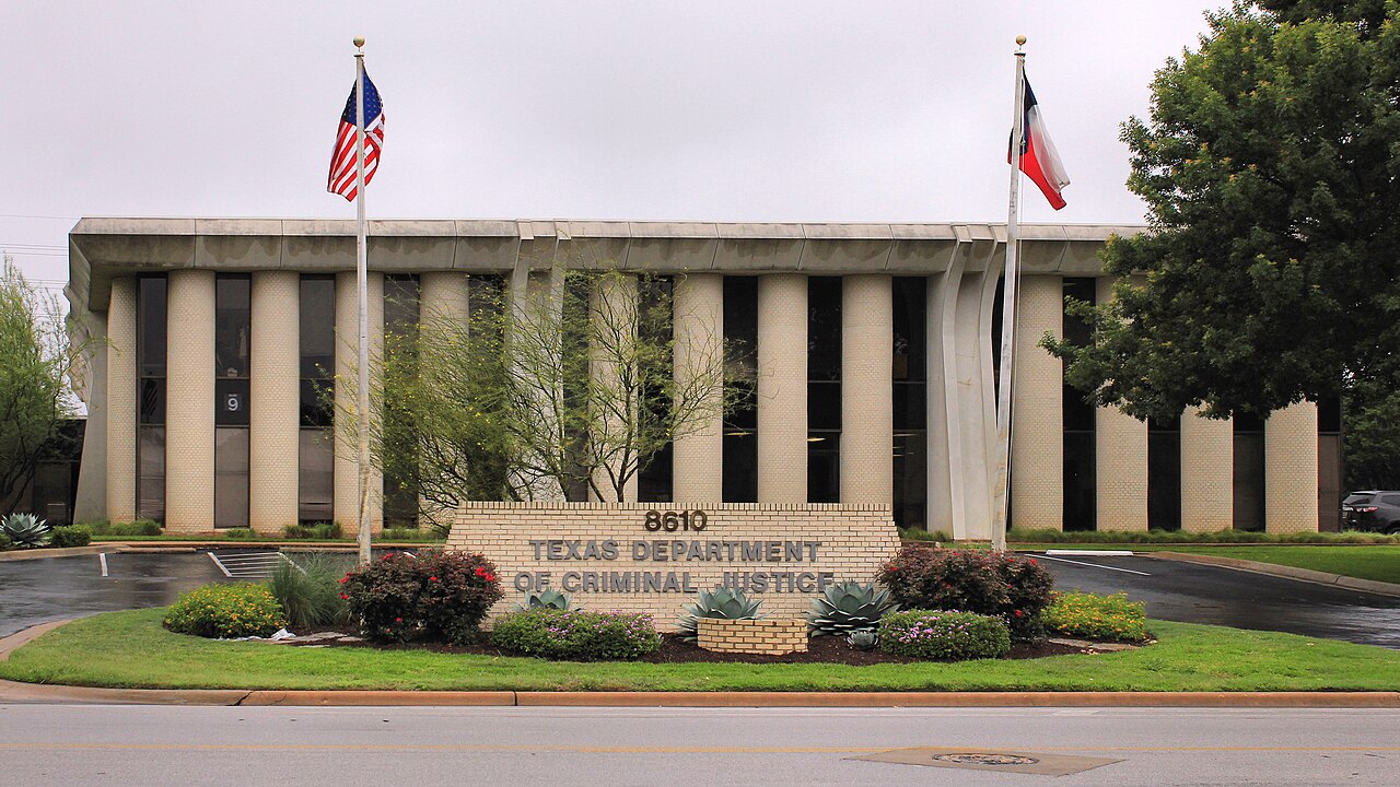 Entrance sign and front of the Texas Department of Criminal Justice offices in Austin, with US and Texas flags