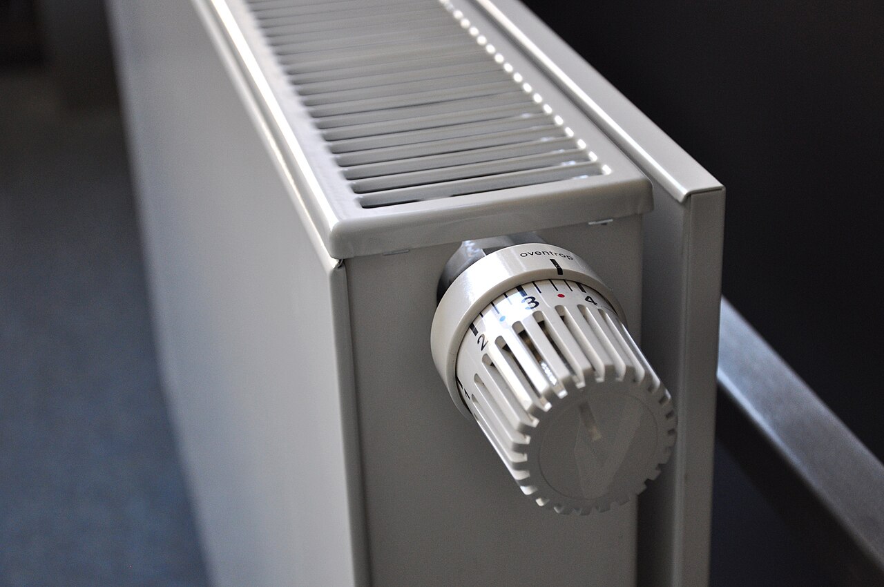 A white home radiator with a thermostatic valve