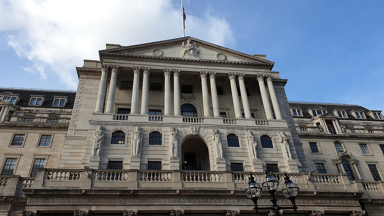 The columned stone front of the Bank of England building in London under a blue sky