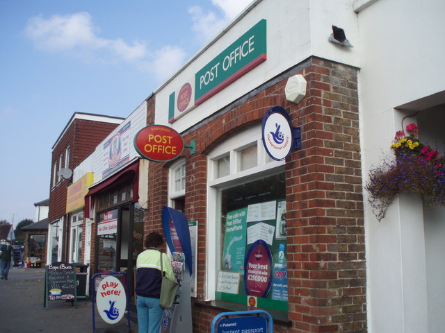 The entrance to a Post Office branch on a UK high street, with the Post Office sign above the door.