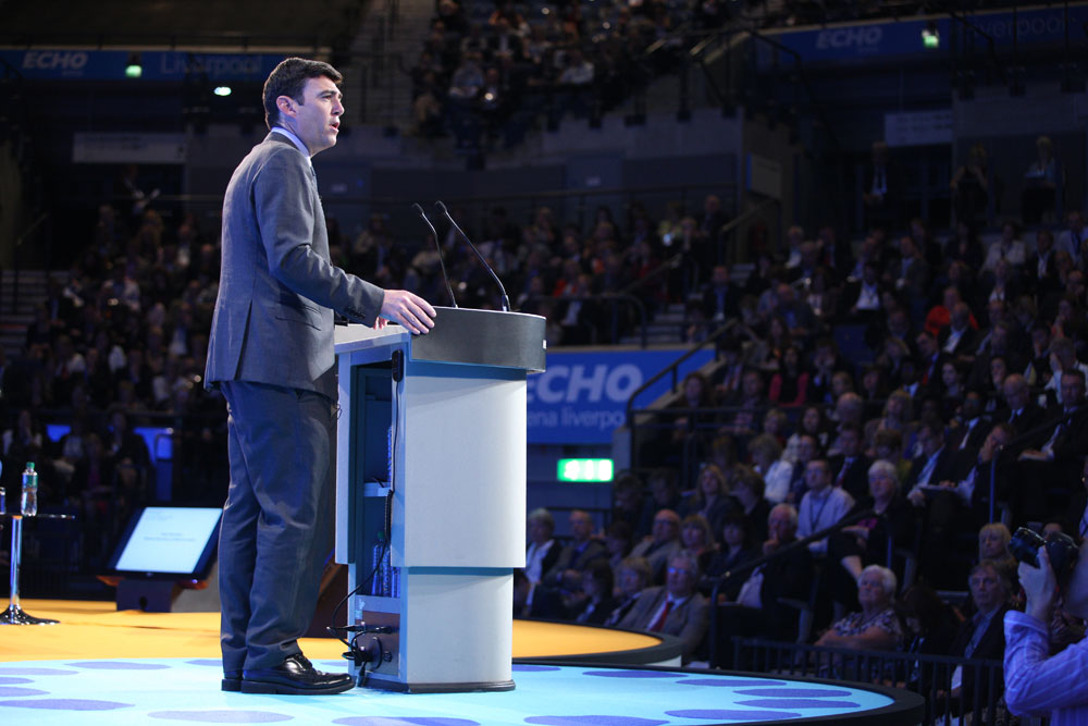 Andy Burnham speaking from a lectern to a conference audience in Liverpool