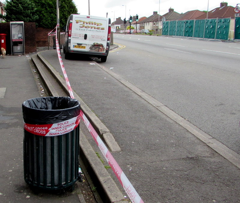 Police cordon tape reading 'police inner cordon - do not cross' strung across a residential street in England