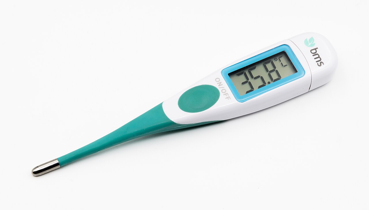 A digital medical thermometer with a green flexible tip and a display reading 35.8°C, photographed on a white background.
