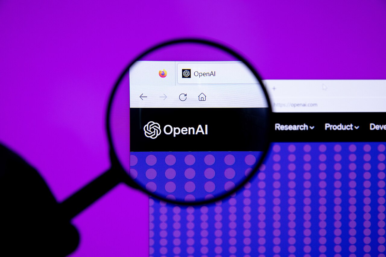 A magnifying glass held over the OpenAI website open in a web browser