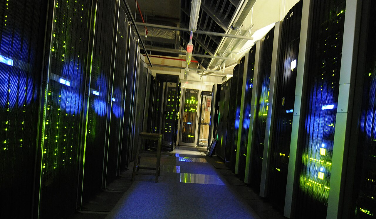 Rows of server racks with green and blue status lights in a server room